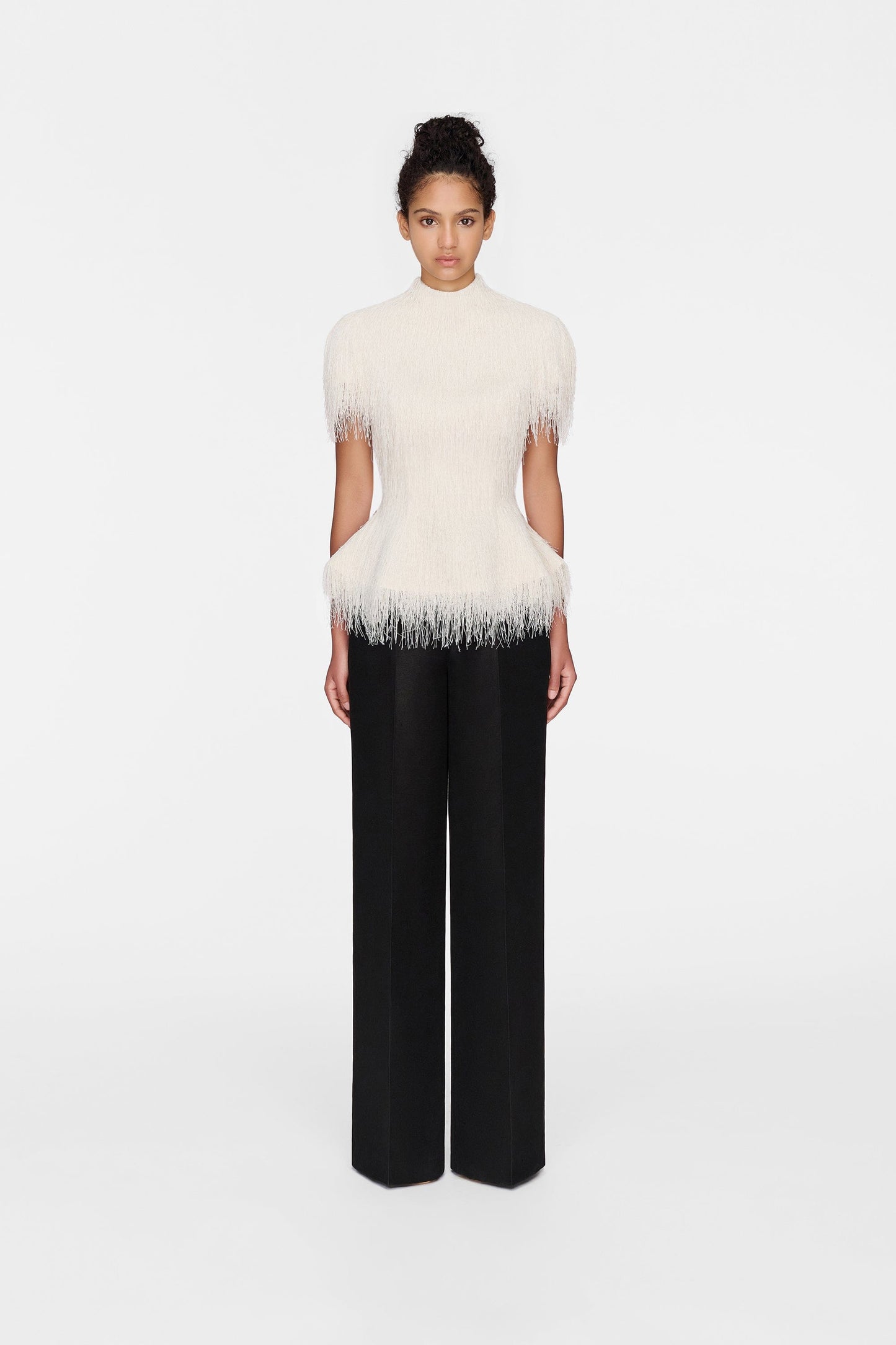 Woman in white feather top and black pants