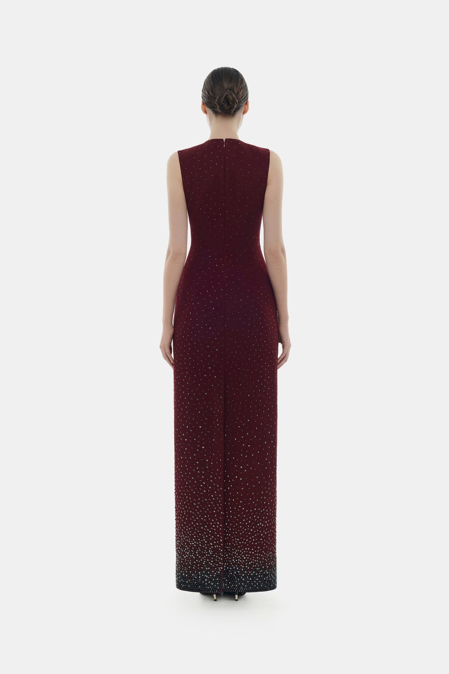 Woman in elegant burgundy gown, back view.