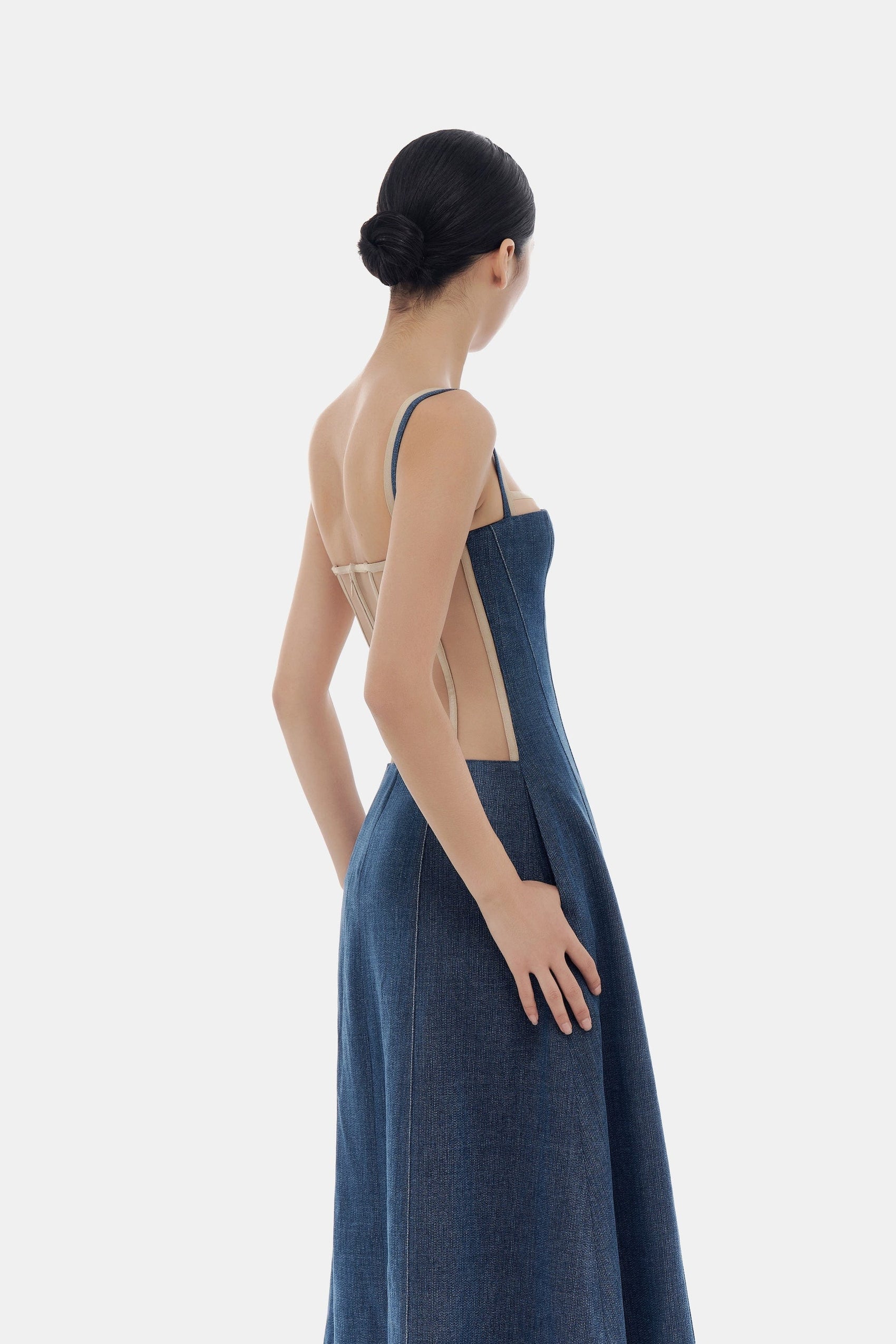 Woman in denim dress, back view.